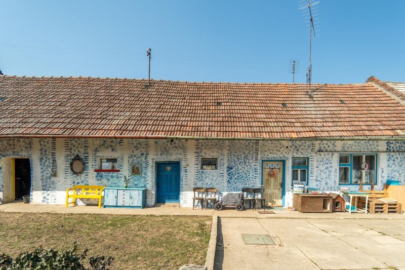 Stavebný pozemok 8 500 m² s podnikateľským potenciálom - Tradičný dom s modrým dekorom a starším nábytkom v Dolnom Lopašove (Pozemky - bývanie).