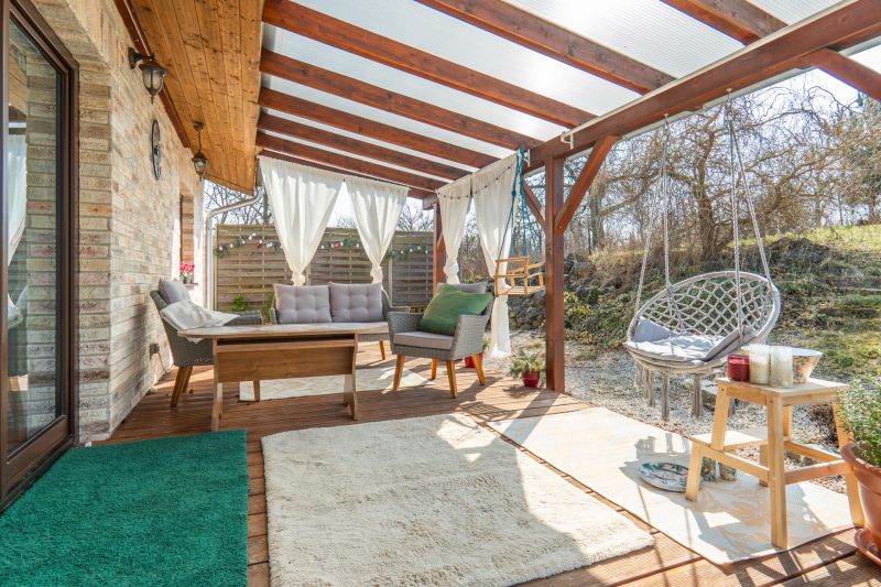 Stavebný pozemok 8 500 m² s podnikateľským potenciálom - Zastrešená terasa s ratanovým nábytkom na pozemku pre bývanie v Dolnom Lopašove.