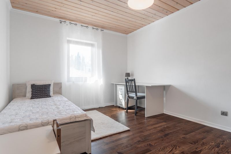 Stavebný pozemok 8 500 m² s podnikateľským potenciálom - Spálňa s posteľou, stolíkom a podlahou s dreveným dekorom. Pozemky - bývanie.