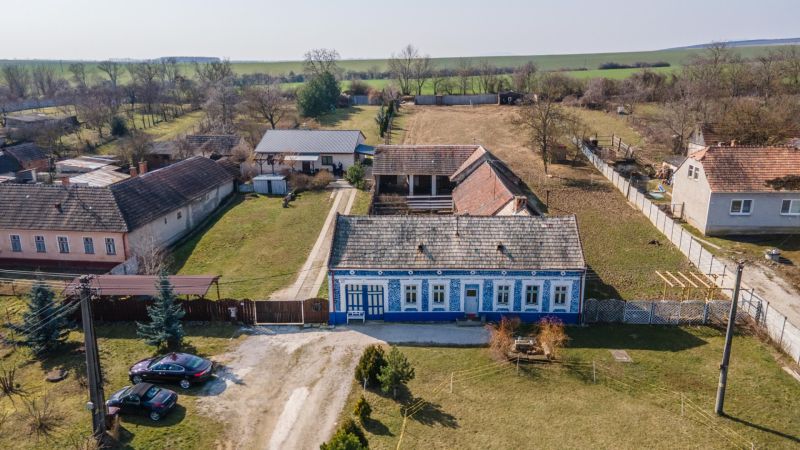 Stavebný pozemok 8 500 m² s podnikateľským potenciálom - Tradičný modrý dom s veľkým dvorom v Dolnom Lopašove, ideálny na bývanie.