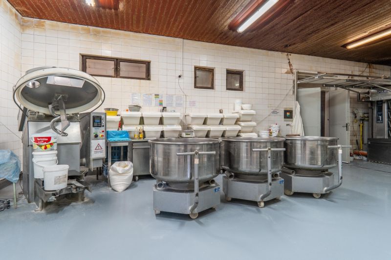I PREDAJ – FUNGUJÚCA PEKÁREŇ A POTRAVINY V TRNAVE - Výrobné priestory s mixérmi, nádobami a podlahou s dreveným dekorom.