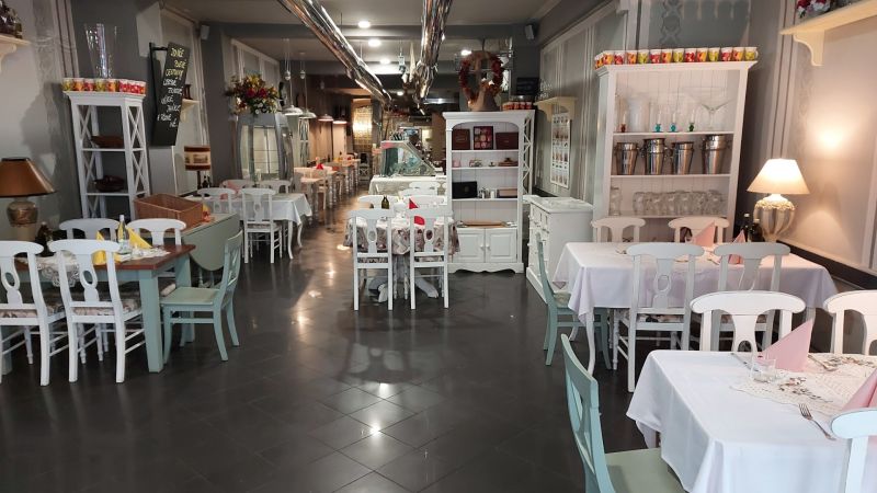ZNÍŽENÁ CENA! I Predaj komerčného priestoru na ul. Obchodna - Interiér obchodných priestorov s bielym nábytkom, elegantnými stolmi a stoličkami.