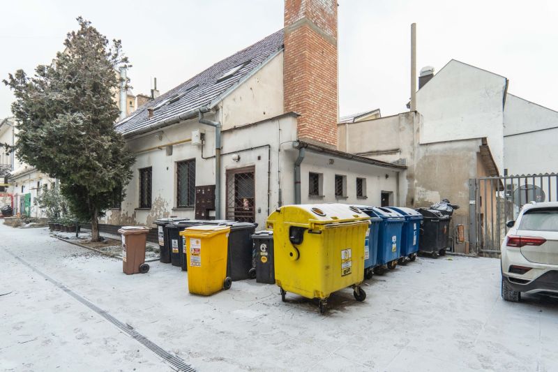 ZNÍŽENÁ CENA! I Predaj komerčného priestoru na ul. Obchodna - Pohľad na zasnežené nádvorie s kontajnermi a staršou budovou v Bratislave - Starom Meste.