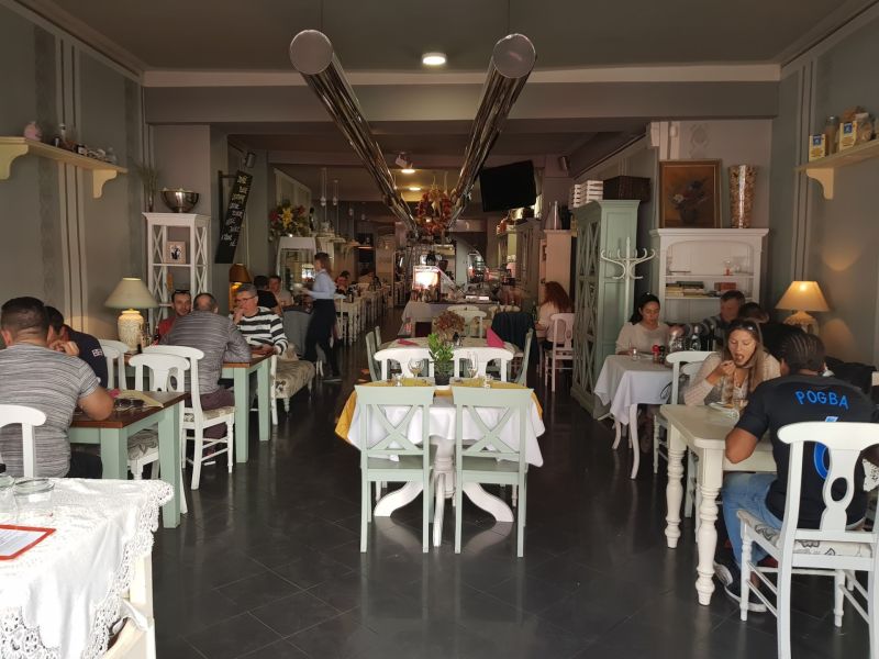 ZNÍŽENÁ CENA! I Predaj komerčného priestoru na ul. Obchodna - Interiér obchodných priestorov s návštevníkmi pri stoloch a dekoráciami v retro štýle.