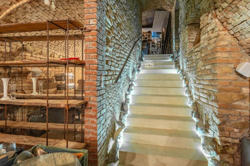 ZNÍŽENÁ CENA! I Predaj komerčného priestoru na ul. Obchodna - Historický klenbový interiér s osvetlenými schodmi a tehlovými stenami v obchodných priestoroch.