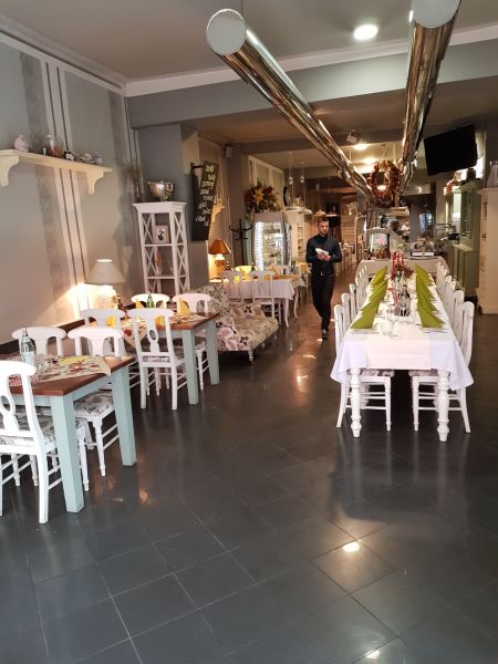ZNÍŽENÁ CENA! I Predaj komerčného priestoru na ul. Obchodna - Interiér obchodných priestorov so stolmi, stoličkami a čašníkom v elegantnej reštaurácii.