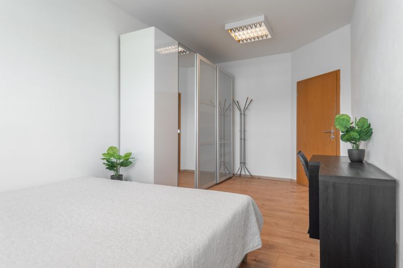 I Predaj priestranného 3-i bytu pri Klientskom centre - Spálňa v 3-izbovom byte s posteľou, skriňou a podlahou s dreveným dekorom.