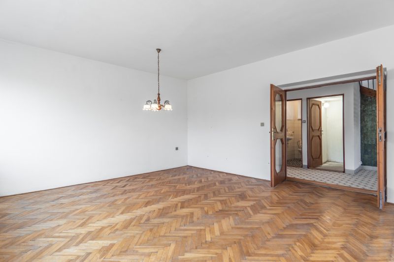 REZERVOVANE  I Na predaj dvojposchodový 5i rodinný dom pri Žiline - Interiér rodinného domu s podlahou s dreveným dekorom a závesným osvetlením.