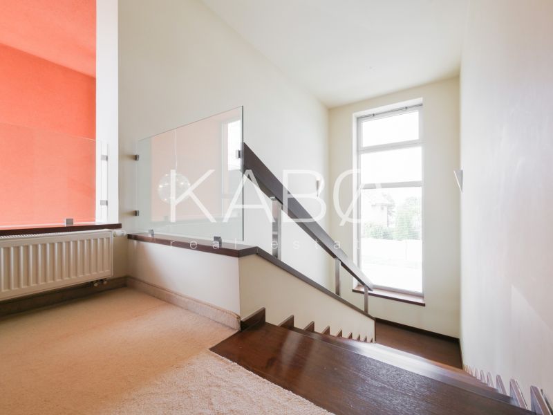 Luxusný RD - upravený pozemok - obľúbená lokalita - Schodisko s moderným zábradlím a kobercom v rodinnom dome, slnečná miestnosť.