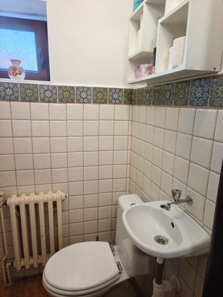 Veľký dom s veľkou garážou v Mankovciach  - Kúpeľňa v rodinnom dome s toaletou, umývadlom a oknom, obložená kachličkami.