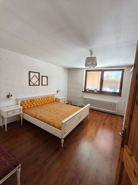 Veľký dom s veľkou garážou v Mankovciach  - Spálňa s posteľou a podlahou s dreveným dekorom v rodinnom dome.