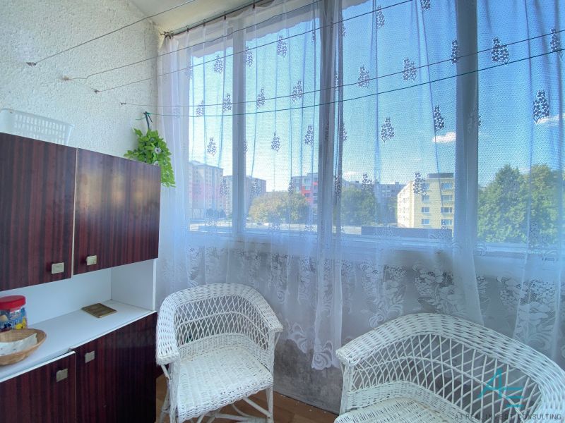 4- izbový byt s halou a lodžiou. - Balkón so štrikovanými kreslami a skrinkou v 4-izbovom byte.
