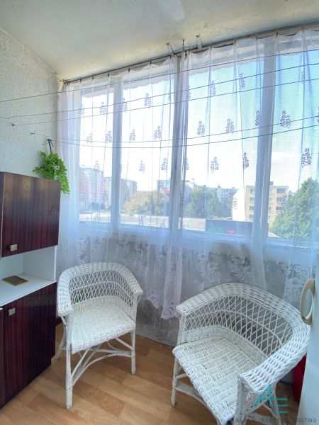 4- izbový byt s halou a lodžiou. - Loggia s prútenými kreslami a výhľadom z 4-izbového bytu s podlahou s dreveným dekorom.