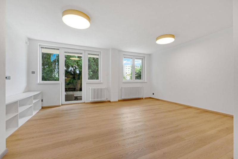 ,Prenájom moderný 3 izb. byt, Sološnícka ul,124 m2, Karlova Ves - Obývacia izba s podlahou s dreveným dekorom v rodinnom dome, presvetlená izbovými oknami.