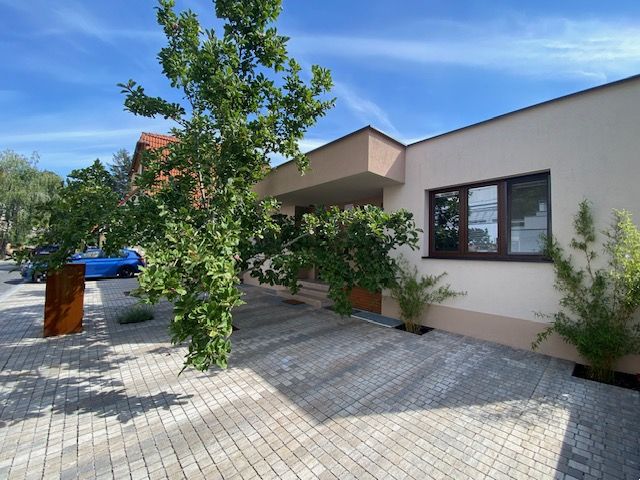 ,Prenájom moderný 3 izb. byt, Sološnícka ul,124 m2, Karlova Ves - Rodinný dom v Bratislave - Karlovej Vsi na Sološnickej ulici obklopujú stromy a dláždený chodník.