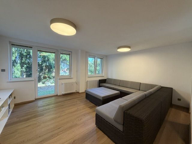 ,Prenájom moderný 3 izb. byt, Sološnícka ul,124 m2, Karlova Ves - Obývacia izba v 3-izbovom byte s rohovou sedačkou a výhľadom do záhrady.