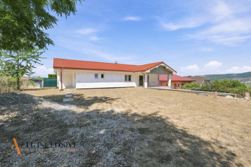 MODERNÁ NOVOSTAVBA | NITRA | MLYNÁRCE | POĽNÁ - Rodinný dom na Poľnej ulici v Nitre s červenou strechou a otvoreným priestorom na dvore.