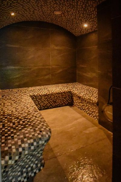 I Dom s wellness, bazénom a hotovým biznis potenciálom - Miestnosť v rodinnom dome s mozaikovým sedením a klenutým stropom.