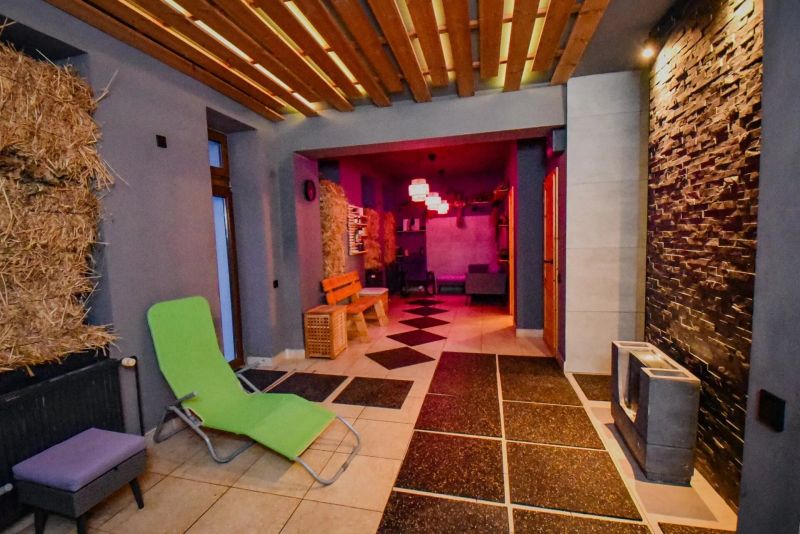 I Dom s wellness, bazénom a hotovým biznis potenciálom - Interiér rodinného domu s relaxačnou miestnosťou a dekoratívnou drevenou stropnou konštrukciou.