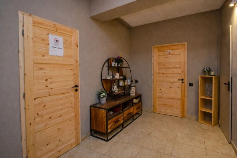 I Dom s wellness, bazénom a hotovým biznis potenciálom - Chodba v rodinnom dome, drevený nábytok, zrkadlo a dve zamknuté dvere.