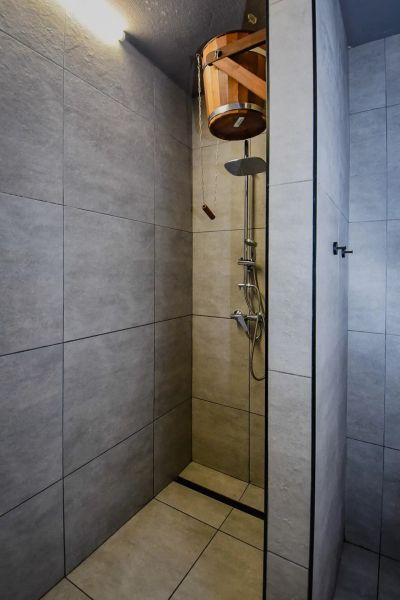 I Dom s wellness, bazénom a hotovým biznis potenciálom - Sprchový kút s vedrom v rodinnom dome, obložený dlažbou.