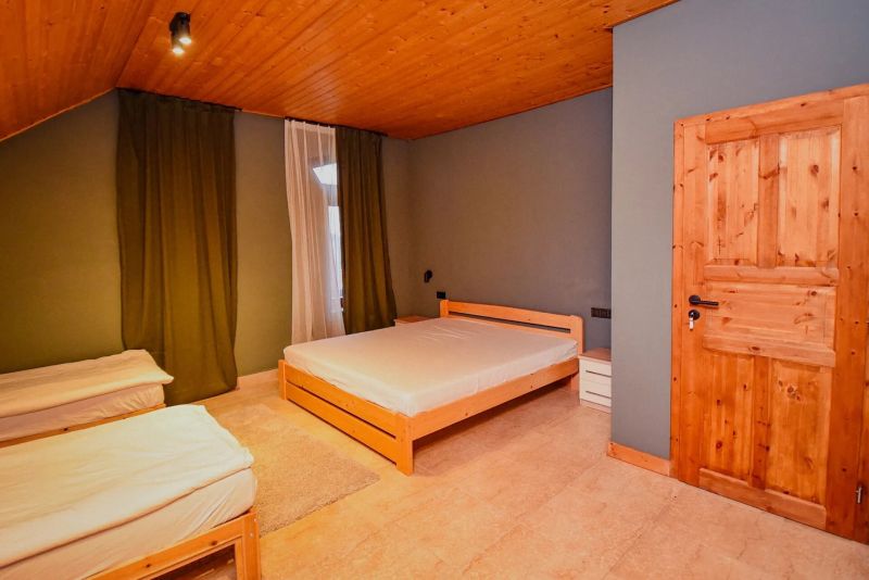 I Dom s wellness, bazénom a hotovým biznis potenciálom - Spálňa v rodinnom dome s drevenými posteľami a podlahou.