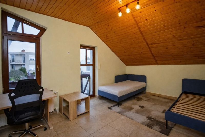 I Dom s wellness, bazénom a hotovým biznis potenciálom - Izba v rodinnom dome s posteľami, písacím stolom a dreveným stropom.