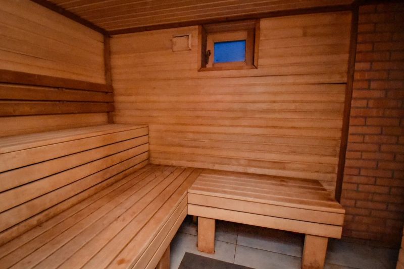 I Dom s wellness, bazénom a hotovým biznis potenciálom - Drevená sauna v rodinnom dome so sedením a malým oknom.