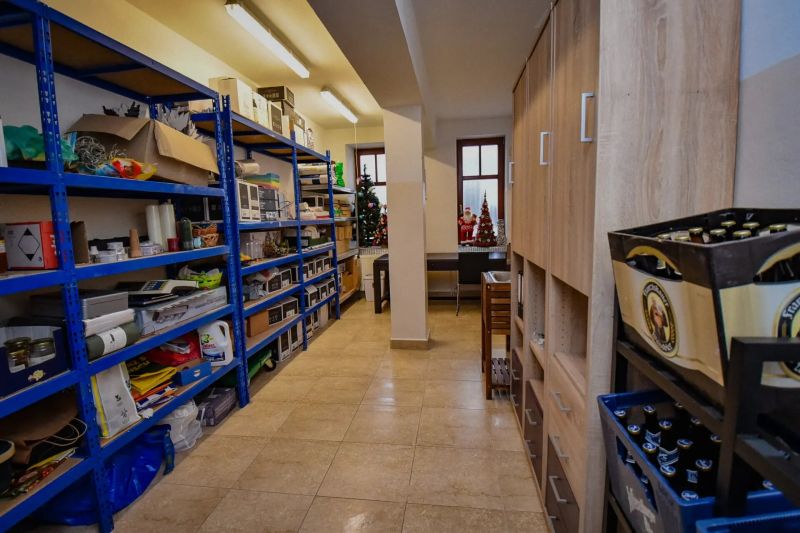 I Dom s wellness, bazénom a hotovým biznis potenciálom - Úložný priestor s regálmi a dekoráciami v rodinnom dome.
