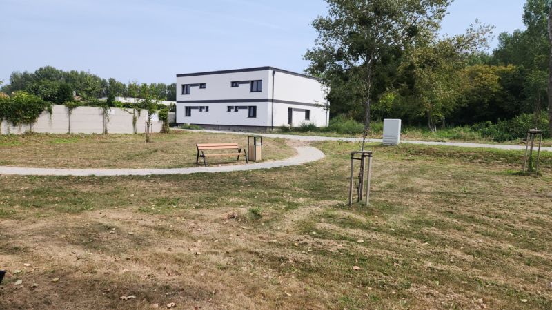 I Predaj 5-i mezonetu s vlastným pozemkom - Park s lavičkou a chodníkom, v pozadí budova v Dunajskom Klátove, 5 a viac izbový byt.