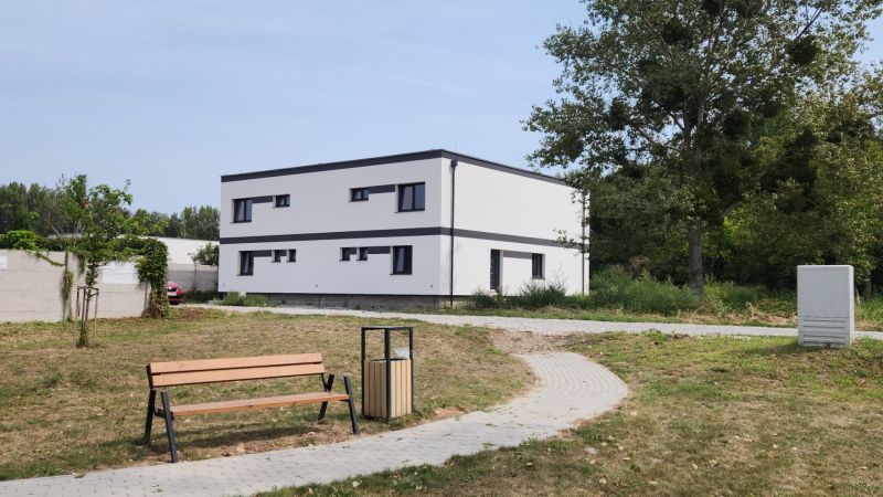 I Predaj 5-i mezonetu s vlastným pozemkom - Moderná stavba v Dunajskom Klátove s trávnikom a lavičkou.