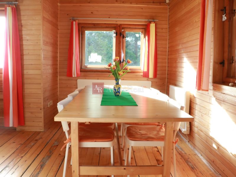 Chalupa Tále, okr.Brezno, pozemok 680m2,  - Drevené obloženie, stôl s kvetmi, podlaha s dreveným dekorom a farebné záclony, Chata.