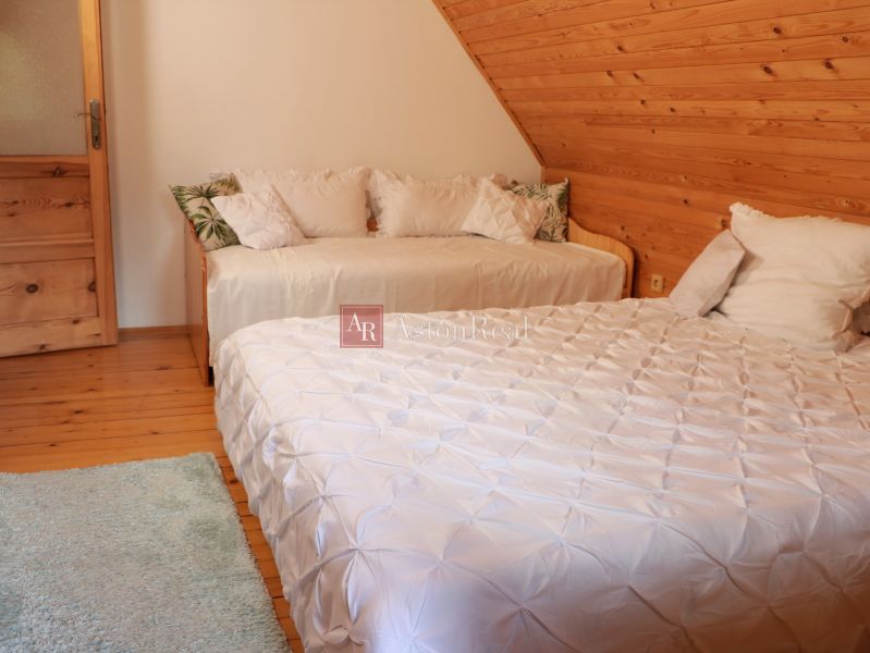 Chalupa Tále, okr.Brezno, pozemok 680m2,  - Spálňa v chate s dvoma posteľami, podkrovím a podlahou s dreveným dekorom.