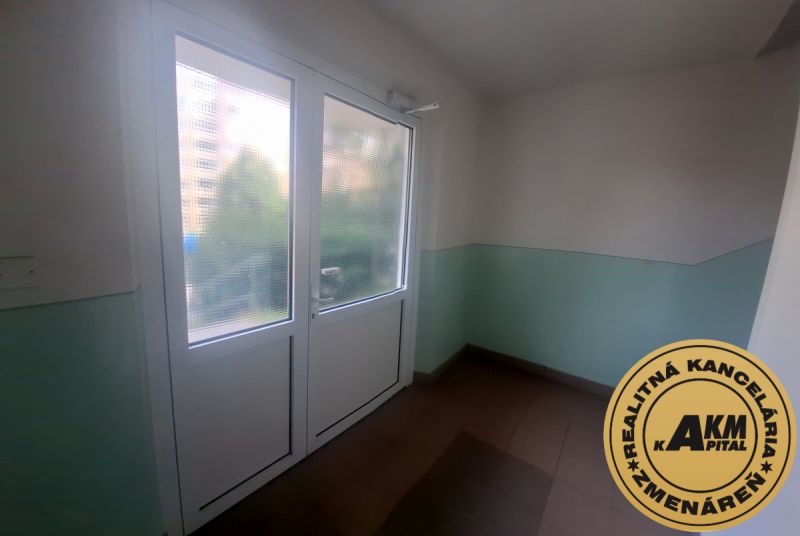 Slnečný 1-izbový byt  na predaj, 42 m2,  J. Gagarina, Zvolen - Vstupná časť bytového domu s veľkými presklenými dverami a šedou podlahou.