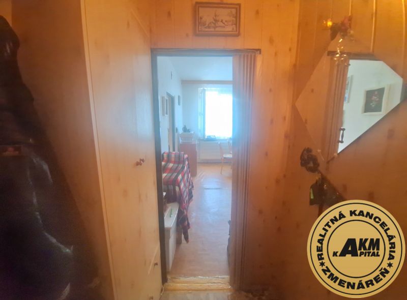 Slnečný 1-izbový byt  na predaj, 42 m2,  J. Gagarina, Zvolen - Chodba v 1-izbovom byte s podlahou s dreveným dekorom a zrkadlom na stene.