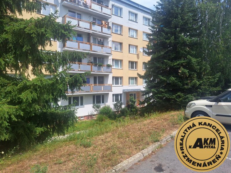 Slnečný 1-izbový byt  na predaj, 42 m2,  J. Gagarina, Zvolen - Bytový dom na Ulici J.Poničana v Zvolenskej Slatine obklopený stromami a zaparkovaným autom.