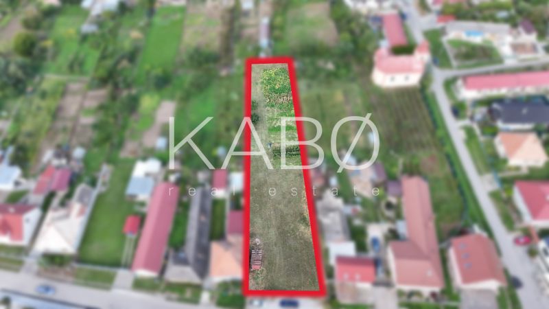 Stavebný pozemok 1 750 m² v centre obce Rumanová - Pozemok na bývanie v Rumanovej so zeleňou a okolitými domami.