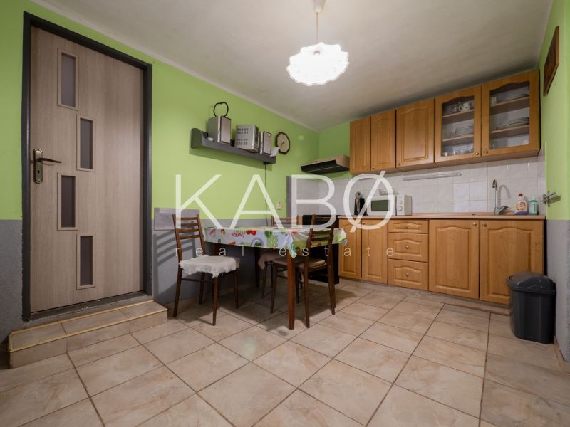 3 izbový Rodinný dom v Cabaj-Čápore s pozemkom 1 053 m² - Kuchynský kútik v rodinnom dome s drevenými skrinkami a zelenými stenami.