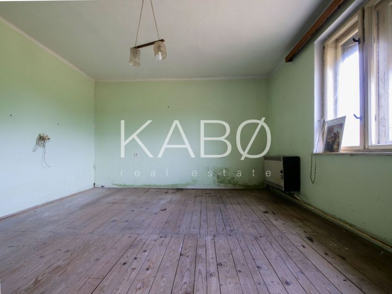 3 izbový Rodinný dom v Cabaj-Čápore s pozemkom 1 053 m² - Izba v rodinnom dome s podlahou s dreveným dekorom, zelené steny, okno vpravo.