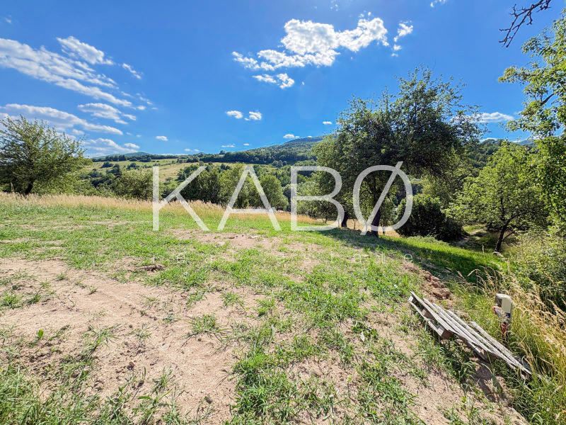 Ideálny Stavebný pozemok 1 353 m² pri Tajchu s krásnymi výhľadmi - Krásna prírodná scenéria s pozemkami na bývanie v Novej Bani, obklopená zeleňou a kopcami.