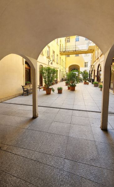 Diamant medzi apartmánmi v srdci Starého mesta - Podloubie s oblúkmi a kvetináčmi na Hviezdoslavovom námestí v Bratislave - Starom Meste.