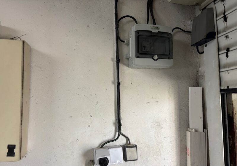 Garáž na ulici Lotyšská v Podunajských Biskupiciach  - Elektroinštalácia v garáži so skriňou a káblami na stene.