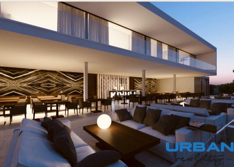 NEDOKONČENÝ BUTIKOVÝ HOTEL A POZEMOK V MATEMWE - Elegantná terasa s pohodlným sedením a dekoratívnou stenou v reštauračnej zóne Pozemky - komerčné.