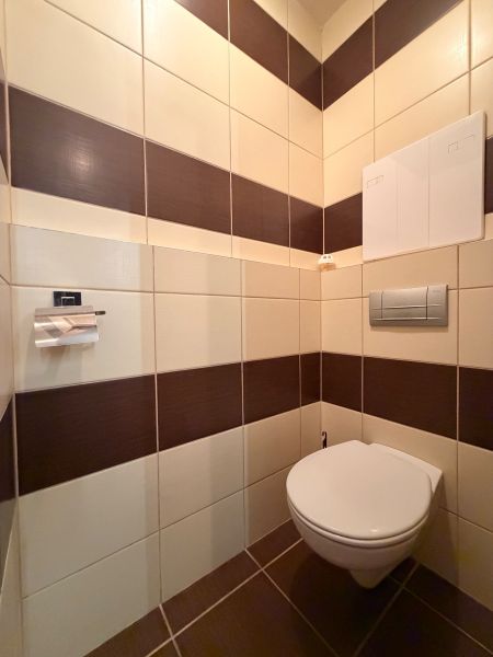 NOVINKA!!! Priestranný 3-izbový byt, 72 m² | Karpatská, Sásová - Toaleta v 3-izbovom byte s hnedo-bielymi obklady.