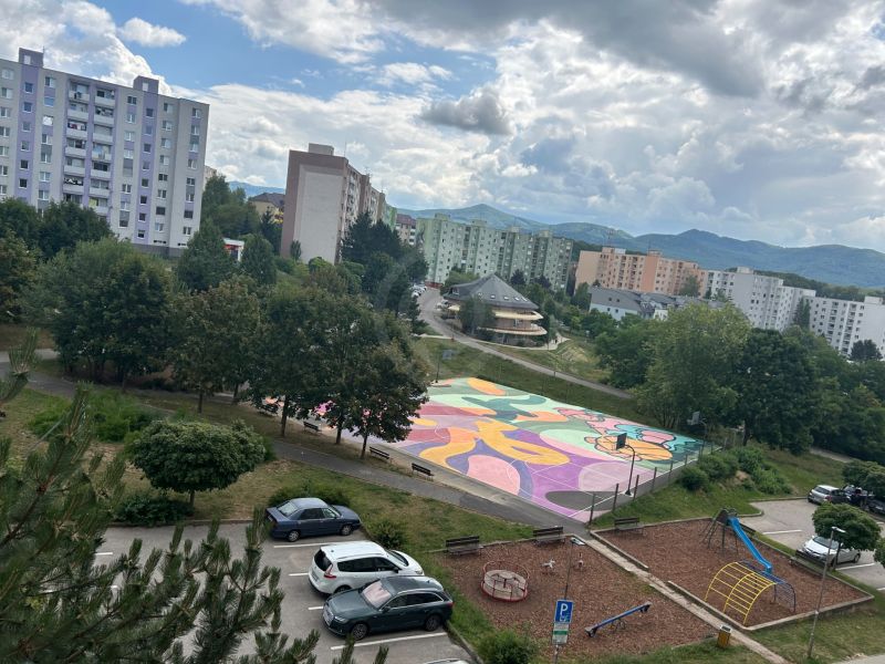 NA PREDAJ PRIESTRANNÝ 3-IZBOVÝ BYT | 67 m² | LODŽIA | 4. POSCHODIE - Pohľad na farebné ihrisko, ihrisko a paneláky na Mateja Bela v Trenčíne.