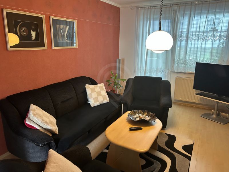 NA PREDAJ PRIESTRANNÝ 3-IZBOVÝ BYT | 67 m² | LODŽIA | 4. POSCHODIE - Obývacia izba v 3-izbovom byte so sedačkou, stolíkom a dekoráciami na stene.