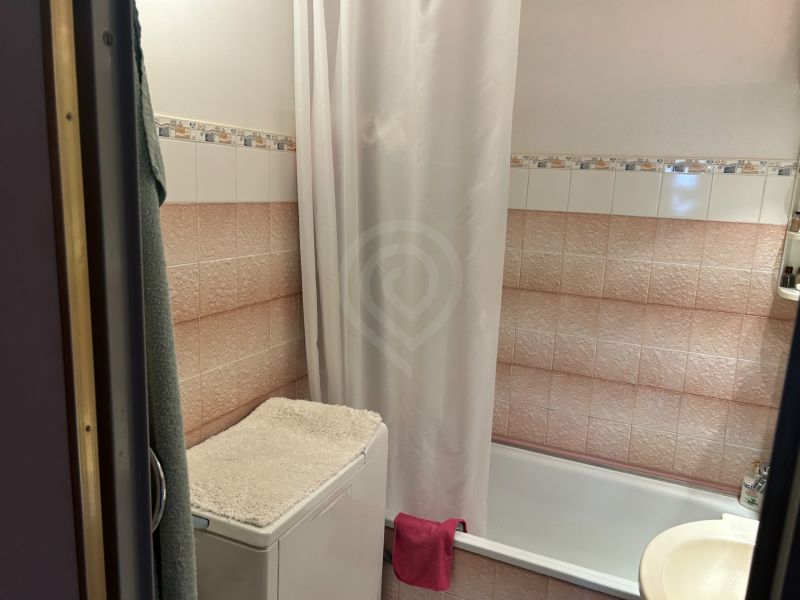 NA PREDAJ PRIESTRANNÝ 3-IZBOVÝ BYT | 67 m² | LODŽIA | 4. POSCHODIE - Kúpeľňa s vaňou, práčka s uterákom a obkladačkami v 3-izbovom byte.