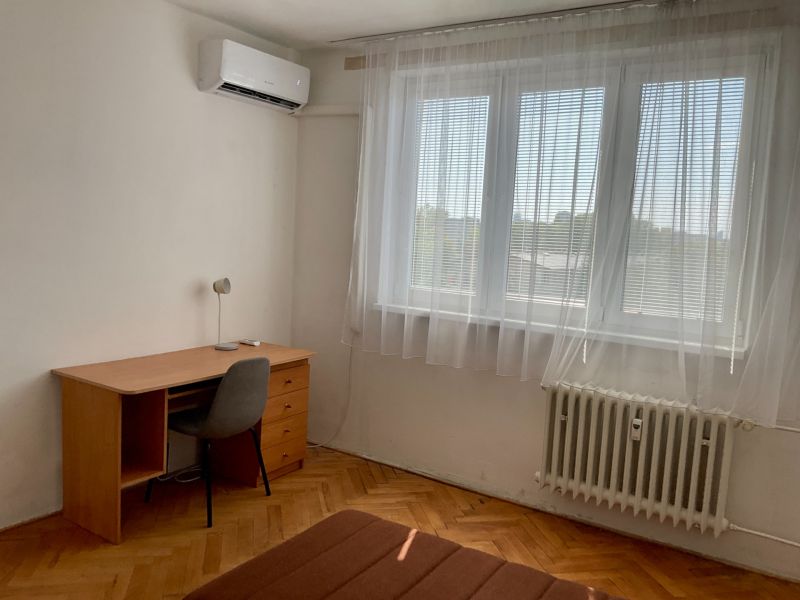 I PREDAJ 2-IZBOVÝ BYT S KLIMATIZÁCIOU A BALKÓNOM I RUŽINOV - Izba v 2-izbovom byte s písacím stolom, stoličkou a klimatizáciou.