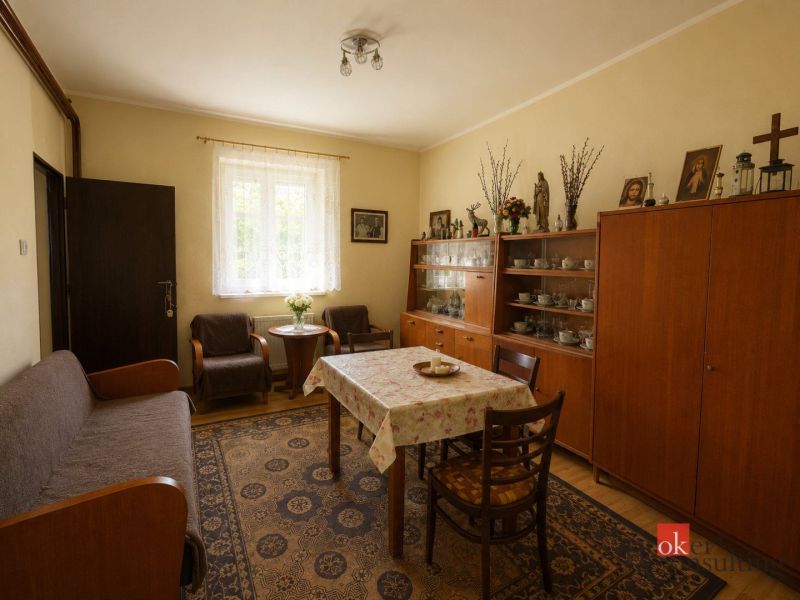 NA PREDAJ - Rodinný dom - Banská Bystrica - CENTRUM - Obývacia izba s dreveným nábytkom, podlahou s dreveným dekorom, kobercom a dekoračnými predmetmi.