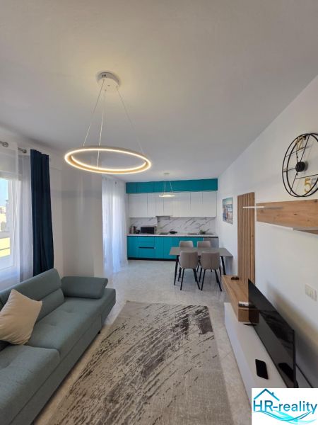 Albánsko, Durres - zariadený apartmán len 100m od mora a pláže - Obývacia izba 2-izbového bytu so štýlovým osvetlením, kuchyňou a pohodlnou sedačkou.